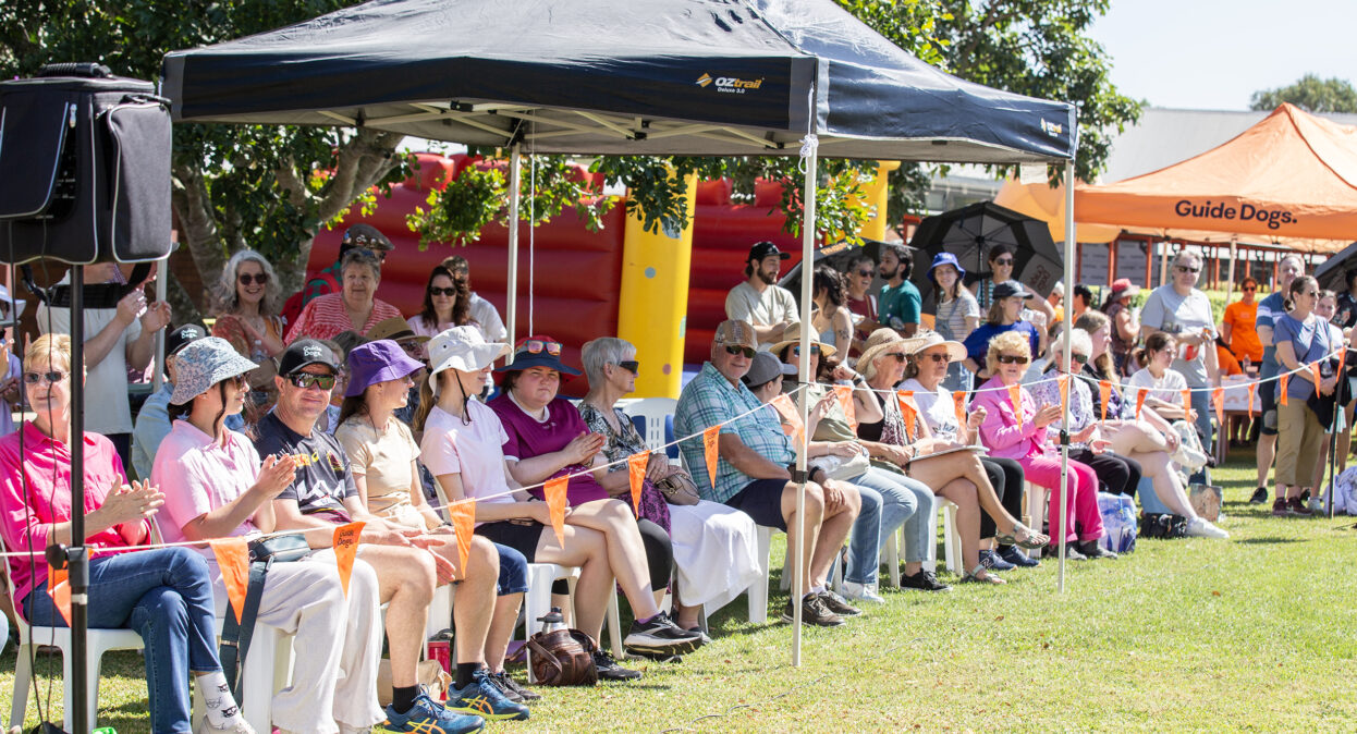 A crowd of spectators sitting along the edge of an arena clapping.