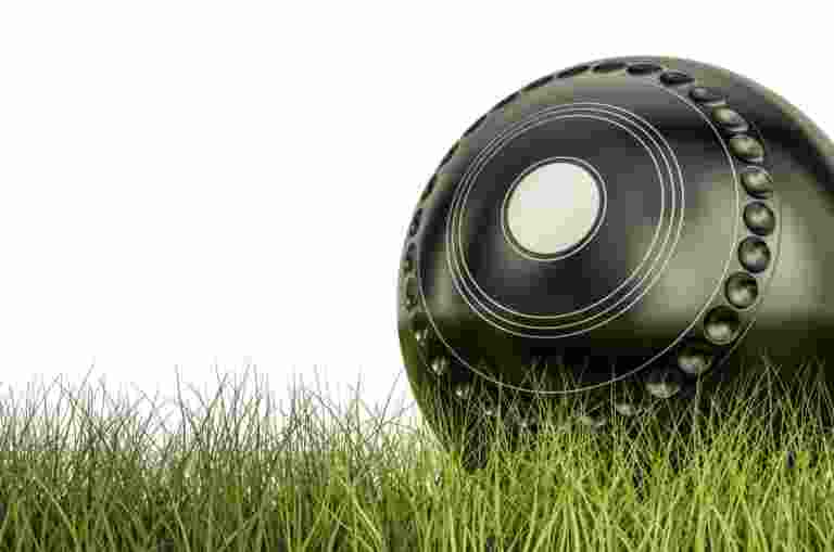 A lawn bowl on a patch of grass.
