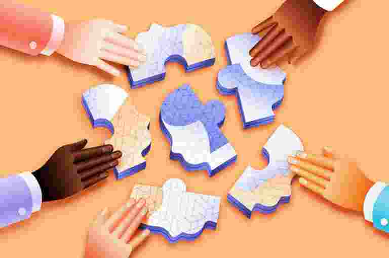 Hands touching a selection of puzzle pieces.