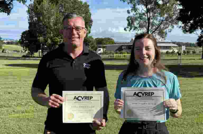 Daniel Ellison and Jessica McLeod proudly hold their COMS certificates outdoors after completing their Certified Orientation and Mobility Specialist training.