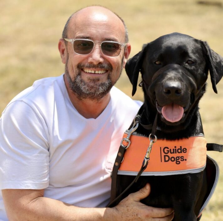 Image of Carlo with a puppy in a training coat.
