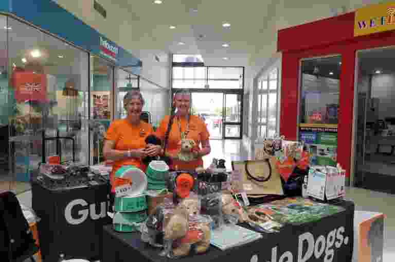 Image shows volunteers running a merchandise stall.