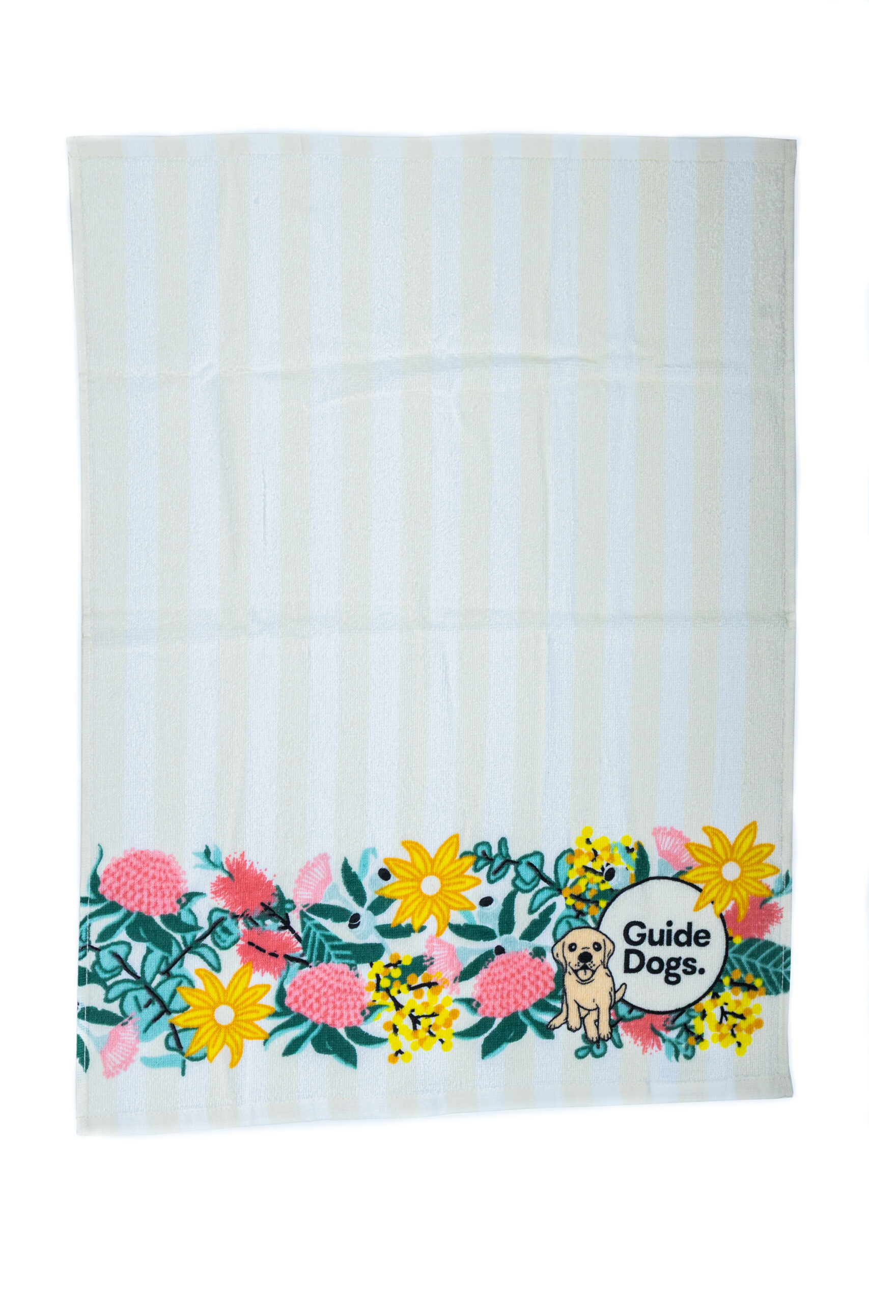 A tea towel with a floral banner pattern and a Guide Dogs logo at the bottom.
