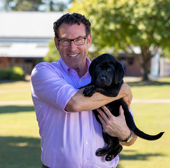 Headshot image of Greg holding a puppy.